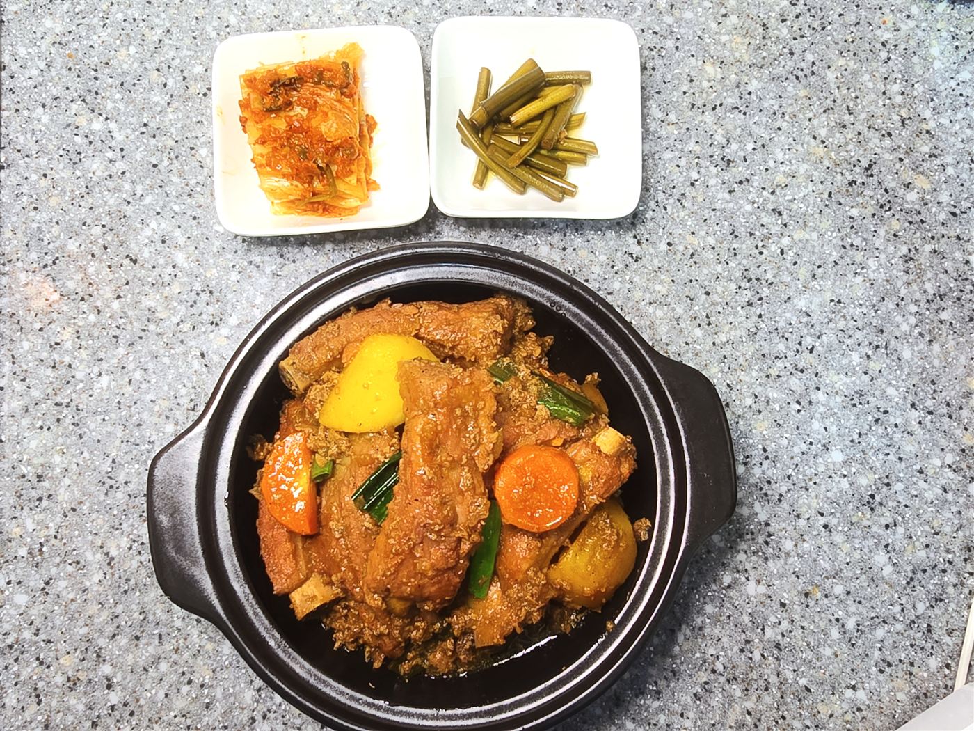 완성한 흑돼지 등갈비찜 한 상 — 김치·마늘종 반찬과 함께, 직접 촬영